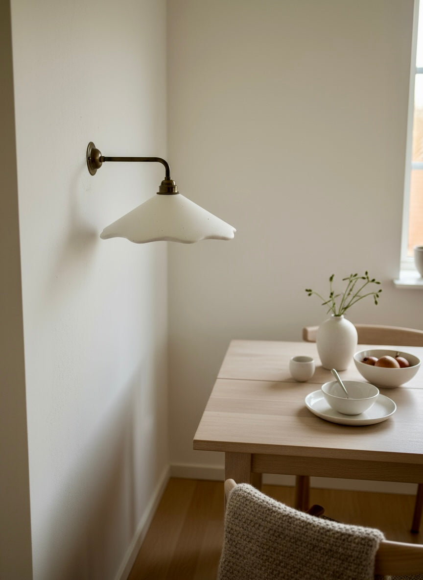 Sculptural wall light in a room with a wooden table and decor items.
