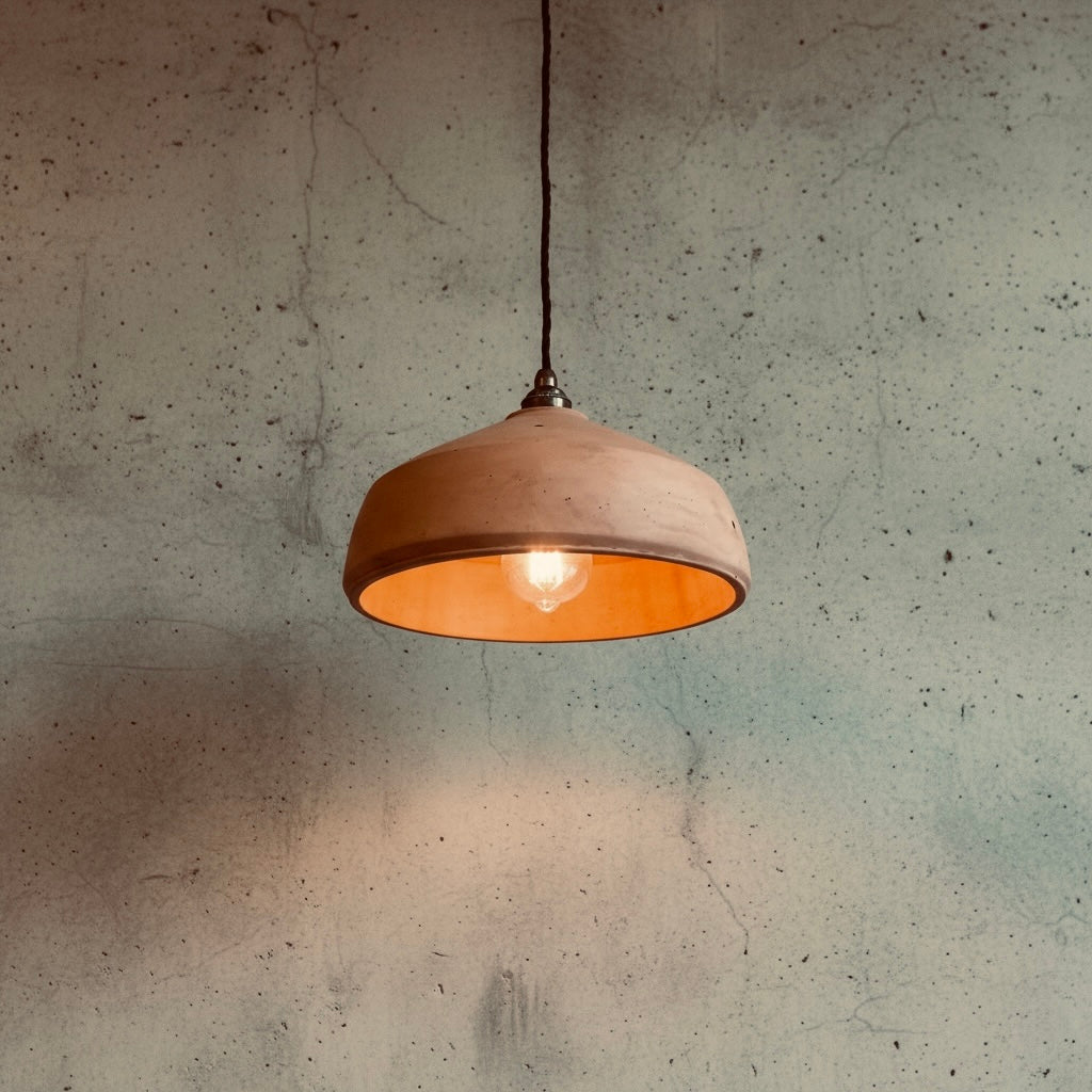 Pendant light hanging against a textured concrete wall