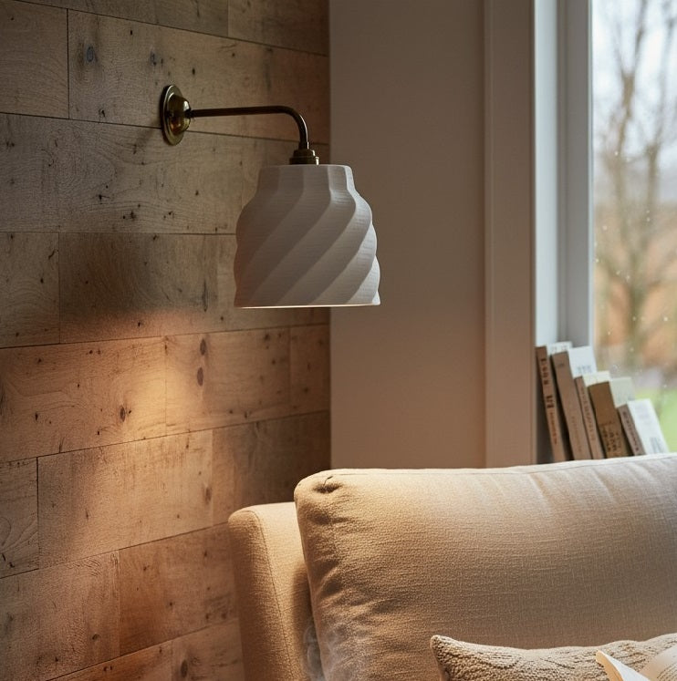handcrafted wall lamp with wavy design on a wooden wall next to a beige sofa.
