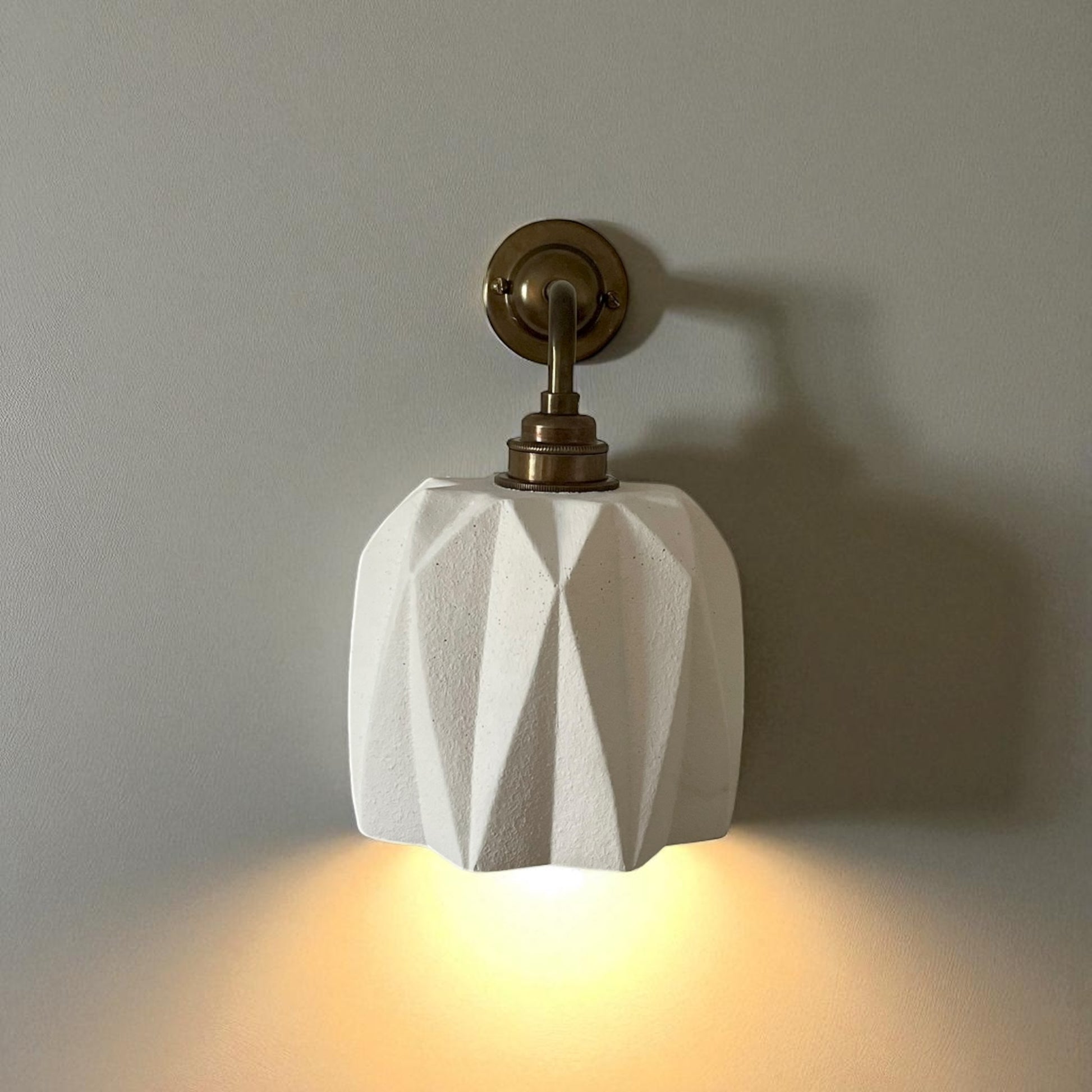 plaster wall light fixture with geometric design on a plain wall