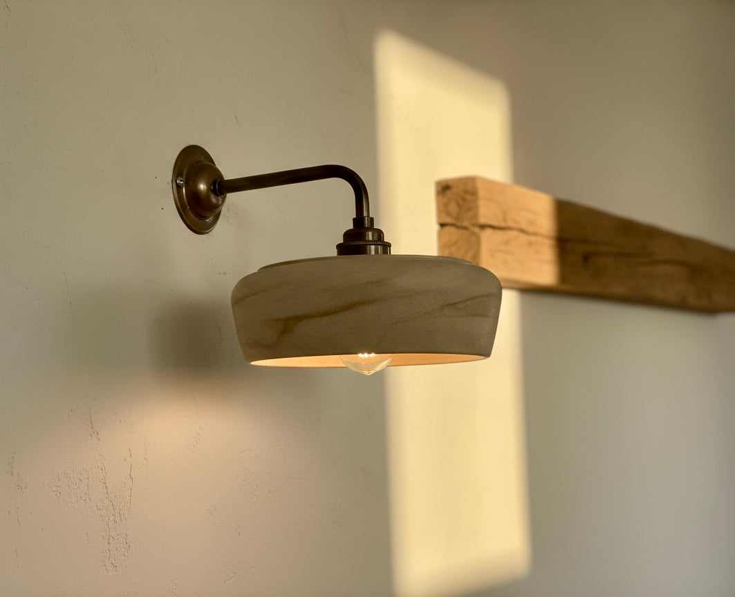 Wall-mounted light fixture casting a shadow on a wall with wooden board