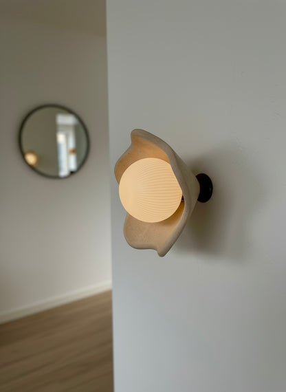 Modern wall light fixture on a white wall with a blurred background
