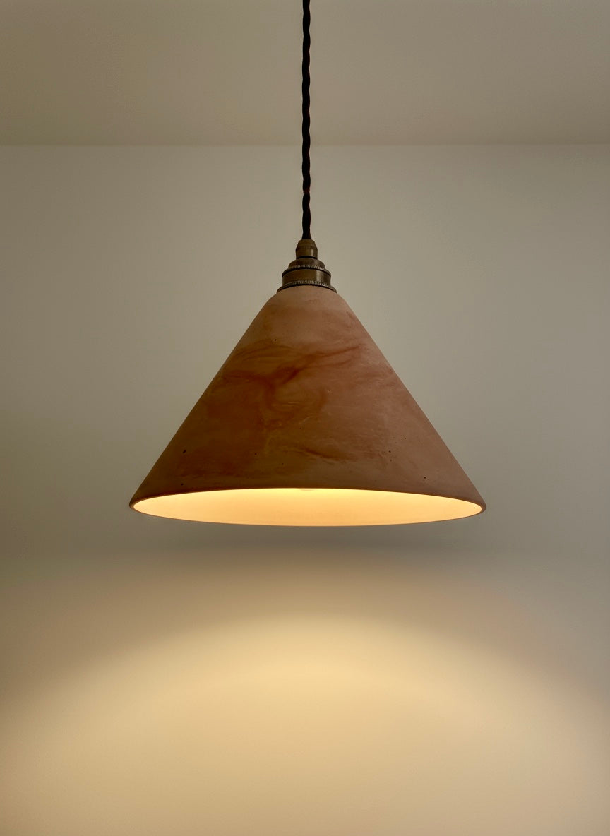 Conical pendant light with a warm glow on a neutral background