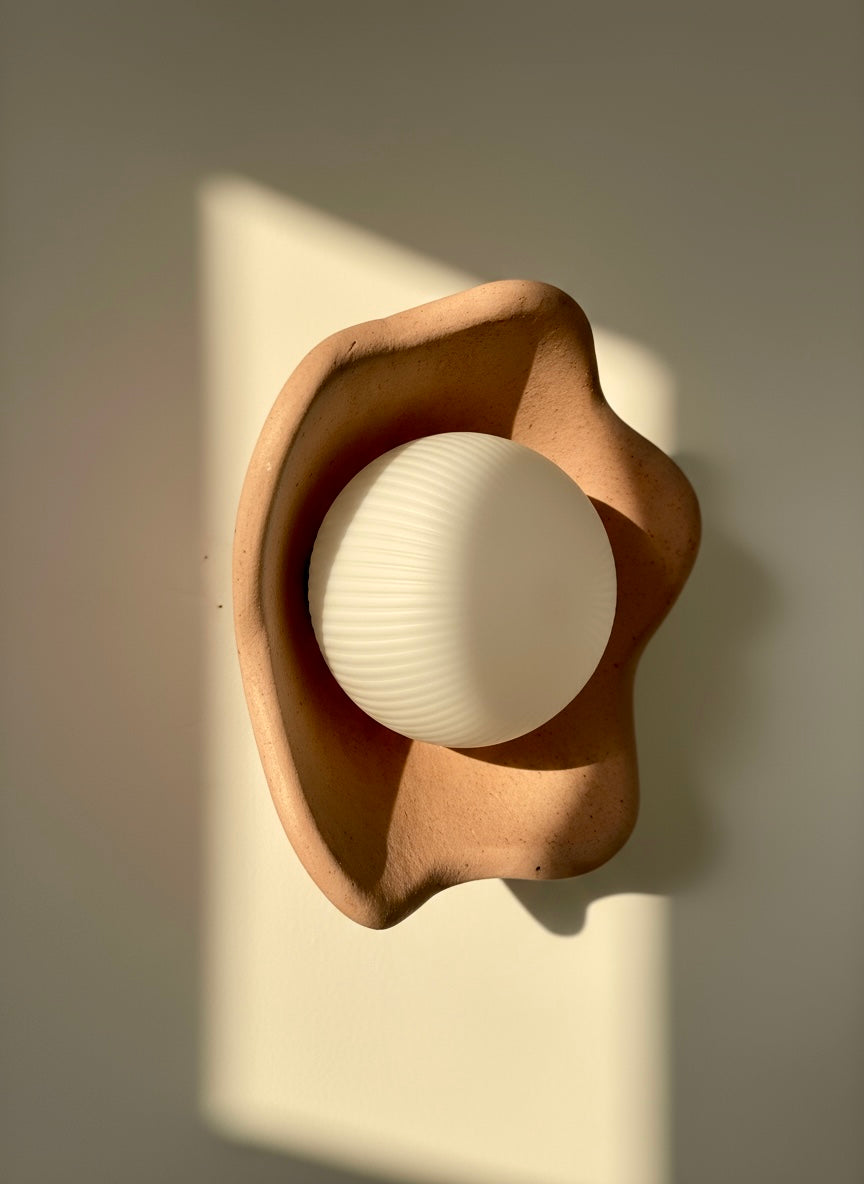 Plaster wall sconce with a white bulb on a neutral background