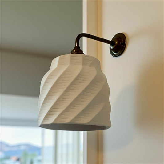 nordic sconce with a textured white shade on a neutral background