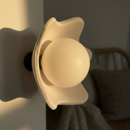Close-up of a wall light fixture with a soft glow in a dimly lit room.