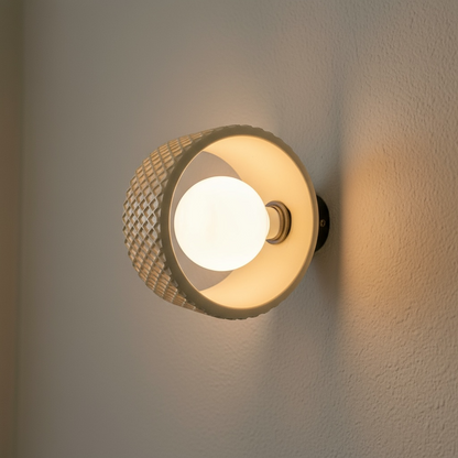 Wall sconce fixture with textured design on a neutral wall.