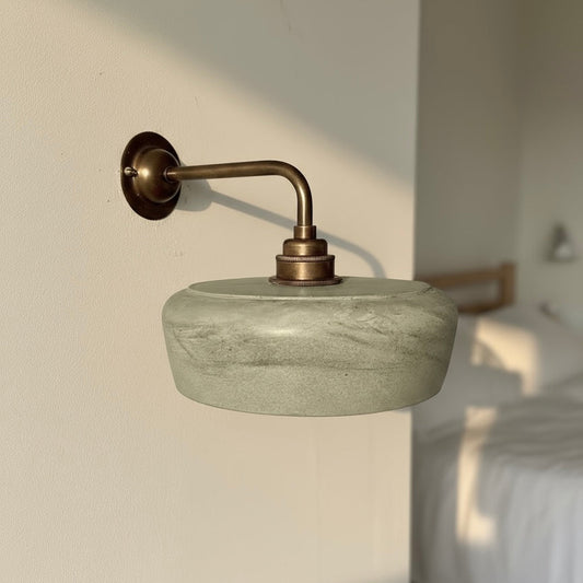 plaster wall light mounted on a wall with brass fixture