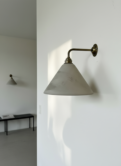 Wall-mounted light fixture with concrete shade on a white wall