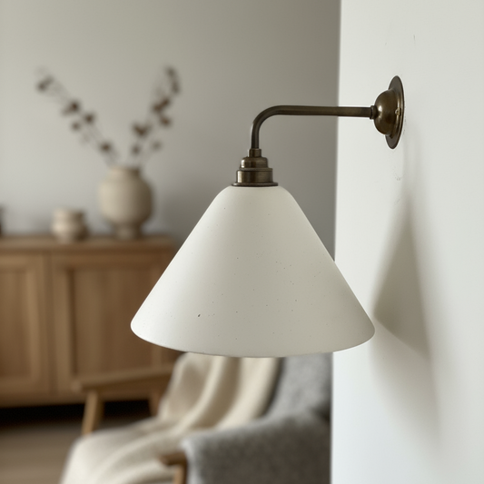 Plaster wall light with a white shade in a cozy room setting.