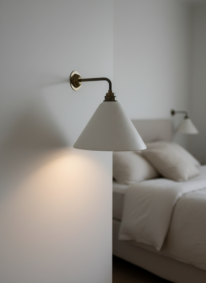 Wall sconce with a white shade in a bedroom setting