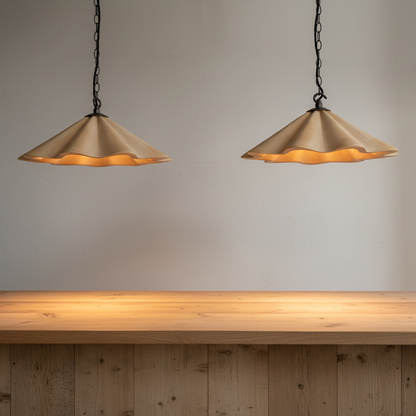 Two pendant lights hanging above a wooden table with a neutral background