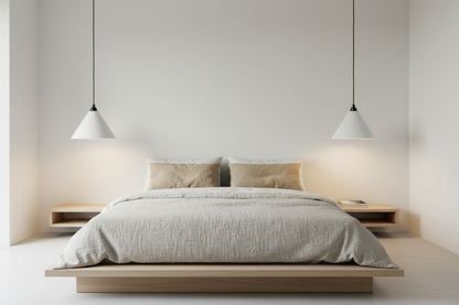 Modern bedroom with a bed and pendant lights on a neutral wall.