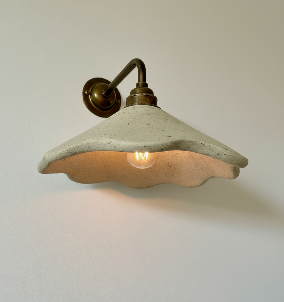 Concrete wall sconce with a light bulb on a plain wall