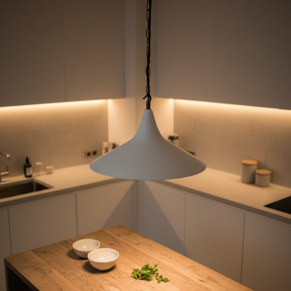 White pendant light hanging above a kitchen counter with bowls and herbs.