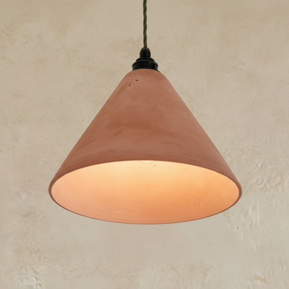 Terracotta-colored pendant light against a beige wall