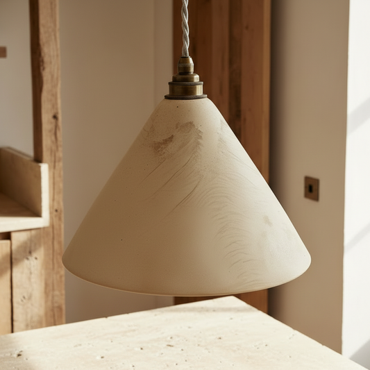 Beige pendant lamp hanging above a wooden table in a softly lit room.