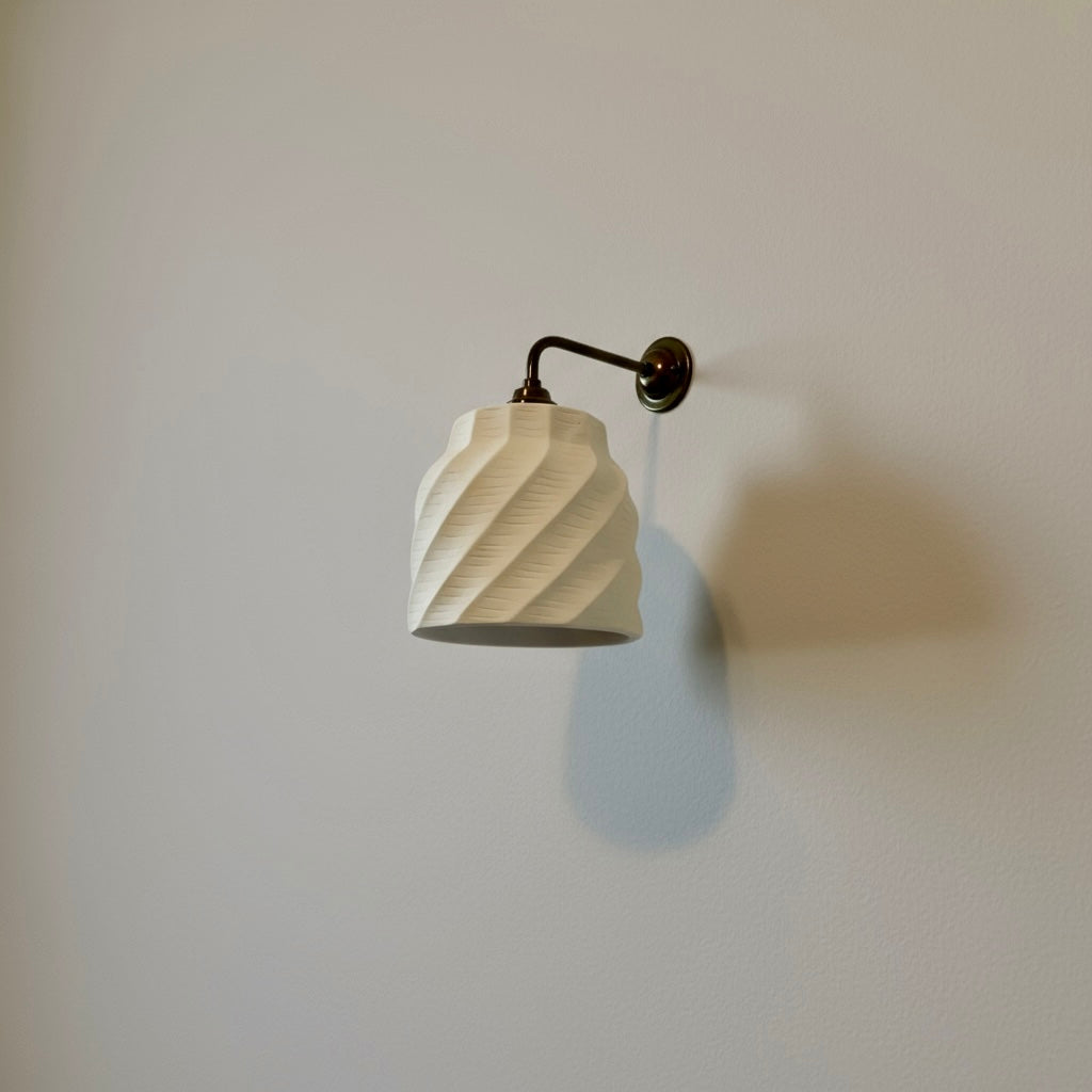 handmade wall lamp with a textured white shade on a plain wall