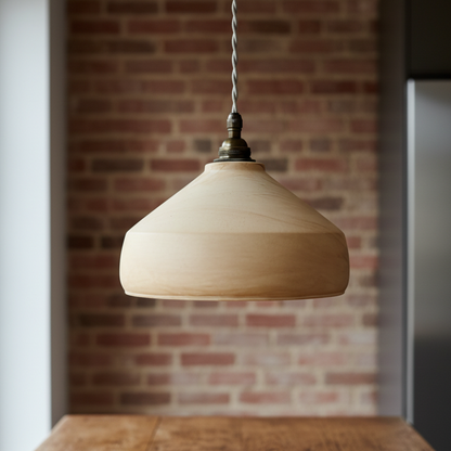 Plaster pendant light hanging above a wooden table with a brick wall background