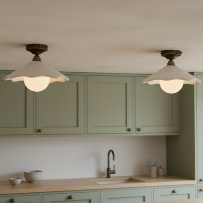 Two ceiling lights in a kitchen with green cabinets and a sink.