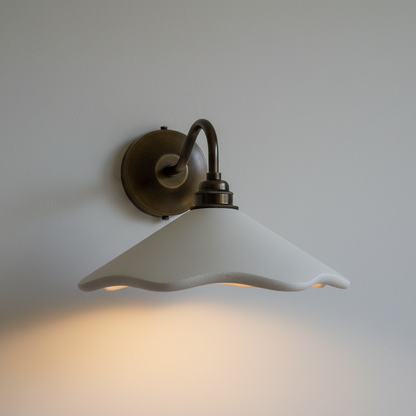 Wall-mounted light fixture with a white glass shade on a plain wall.