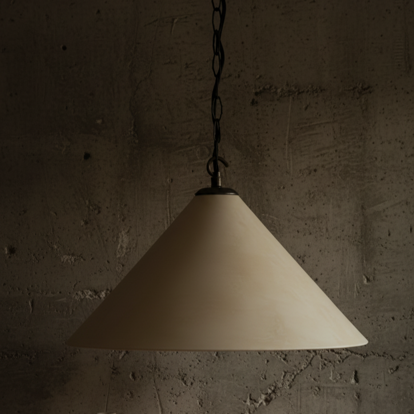 Beige pendant light hanging against a textured brown wall