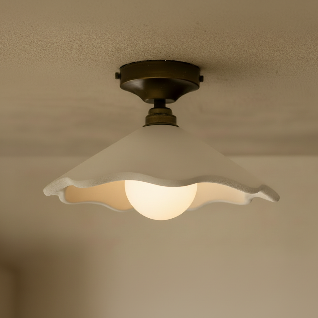 Ceiling light fixture with wavy glass shade on a beige ceiling