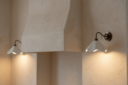 Two wall-mounted lights on a textured beige wall