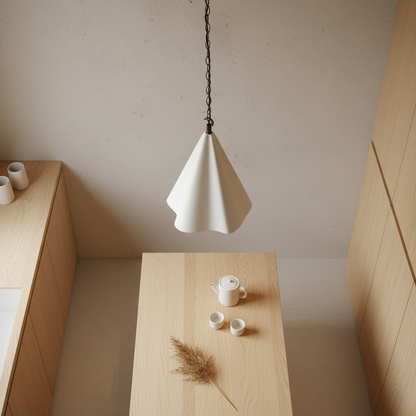 Minimalist interior with a white pendant light, wooden table, and neutral decor.