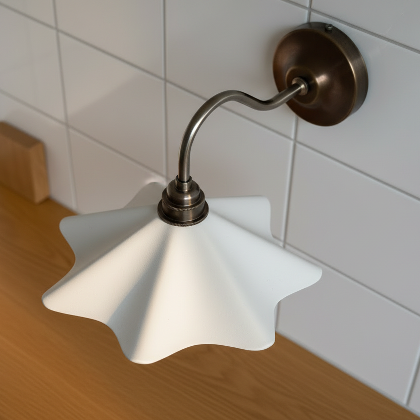Wall-mounted lamp with white shade and bronze fixture against a tiled wall.