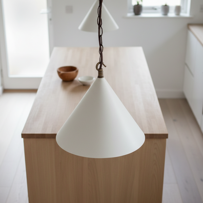 White cone-shaped pendant light hanging over a wooden kitchen island.
