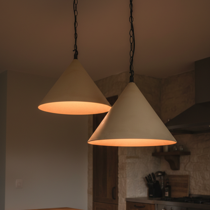 Two cone-shaped pendant lights hanging in a kitchen setting.