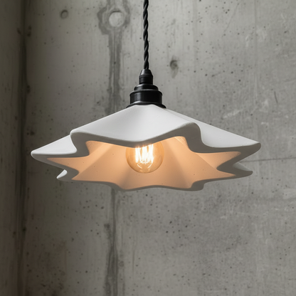 Pendant light with a unique shade hanging against a concrete wall.