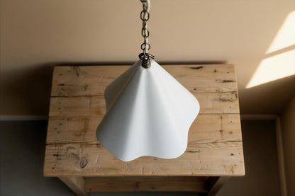 White cone-shaped lampshade on a wooden surface with a neutral background