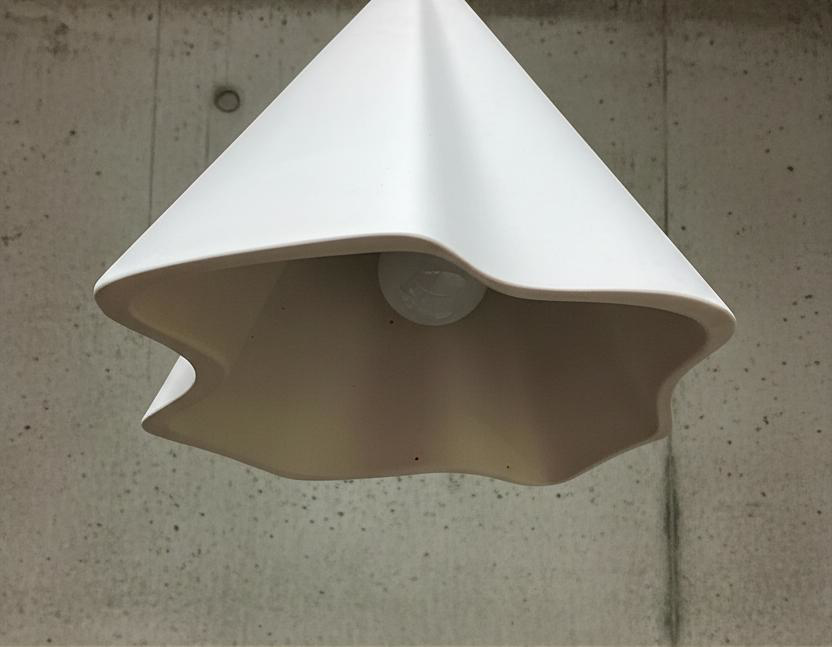 White pendant light fixture on a concrete wall