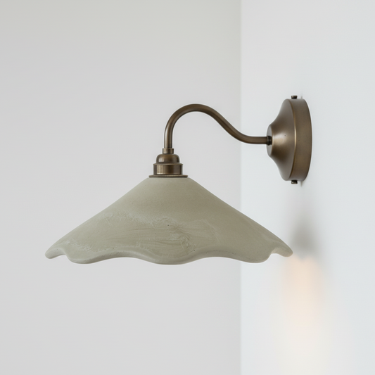 Wall sconce fixture with a green shade on a white background