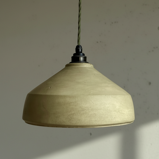 Pale green pendant light hanging against a plain wall