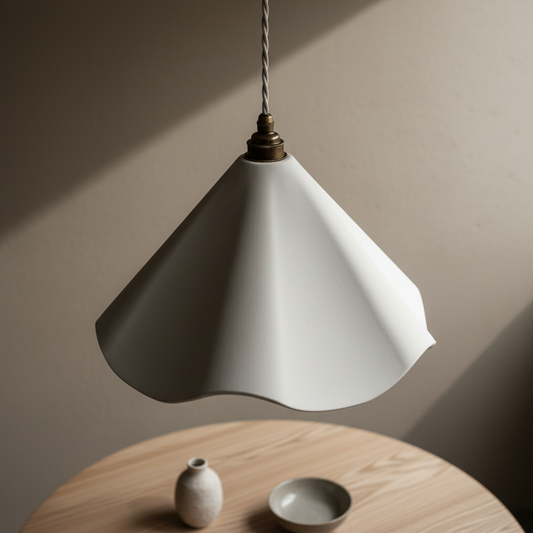 White pendant lamp hanging above a wooden table with a vase and bowl.