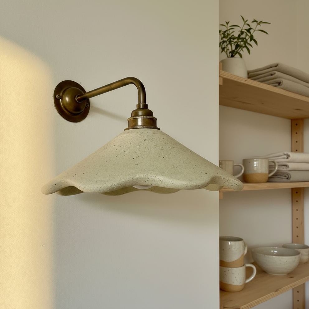 Wall-mounted lamp with a textured beige shade in a cozy room setting.
