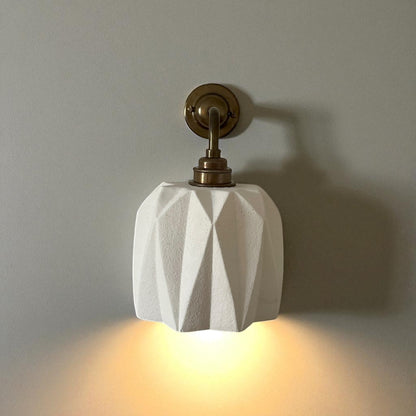 plaster wall light fixture with geometric design on a plain wall