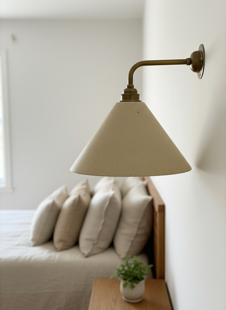 Beige wall lamp on a white wall with a sofa and pillows in the background