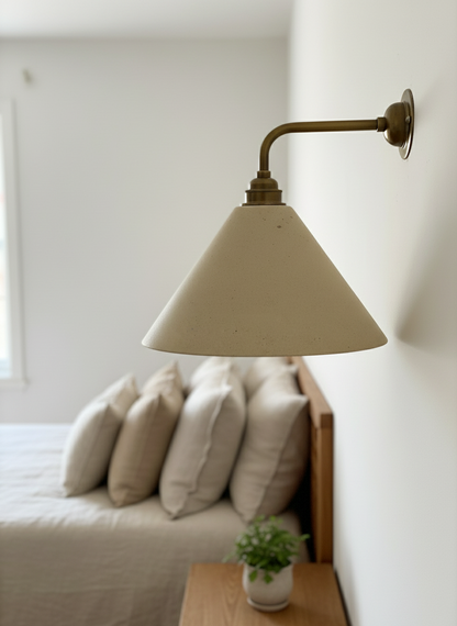 Beige wall lamp on a white wall with a sofa and pillows in the background
