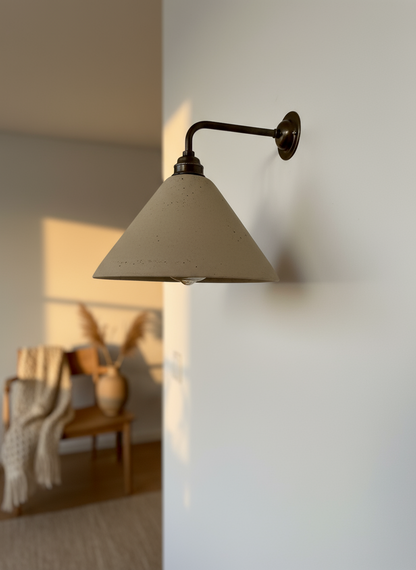 Wall-mounted lamp with a beige shade in a softly lit room.