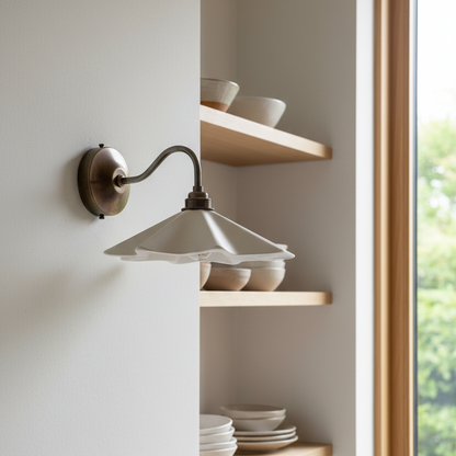 Wall-mounted light fixture with shelves holding ceramic bowls in a room with a window.