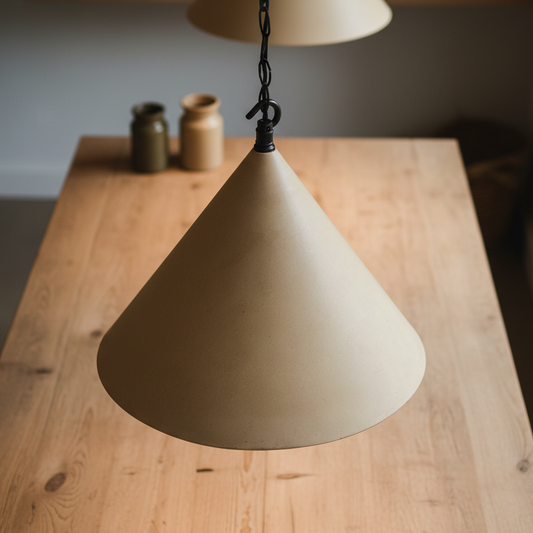 Beige cone-shaped lampshade hanging over a wooden table with a blurred background