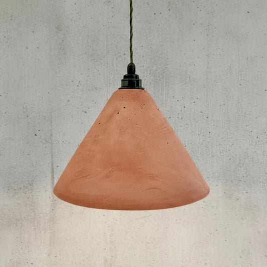 Terracotta pendant light against a concrete wall background