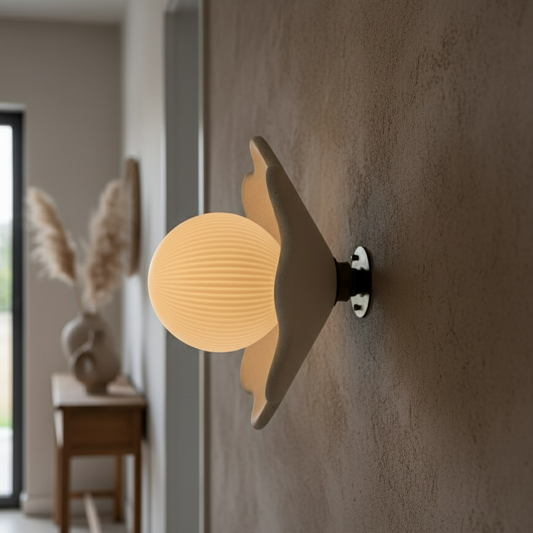 Decorative wall light fixture on a textured wall with a blurred indoor background