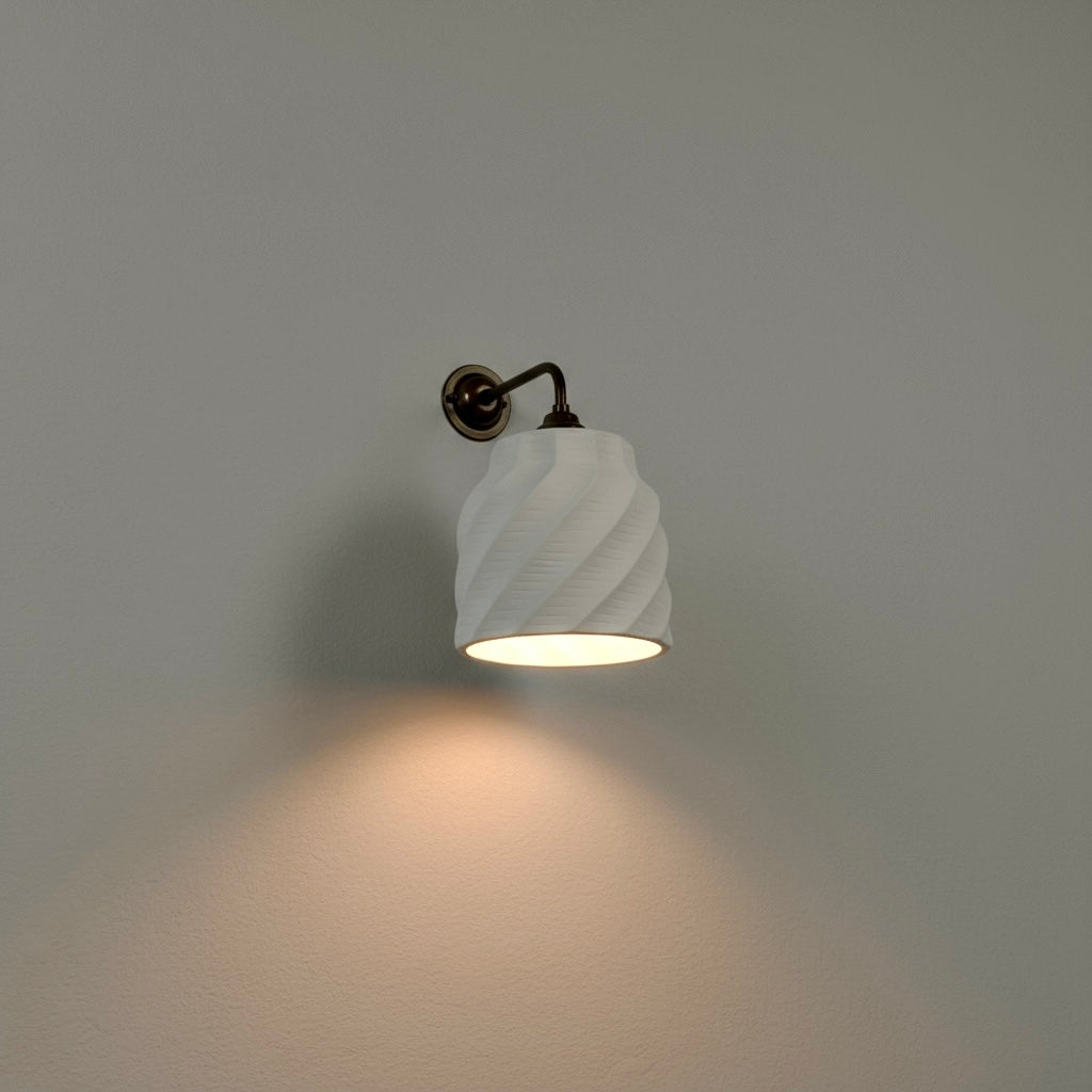organic wall lighting fixture with a textured white shade on a gray wall.