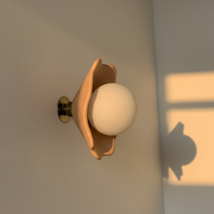 Wall-mounted lamp with a soft glow on a neutral wall, next to a wooden surface with a small vase.
