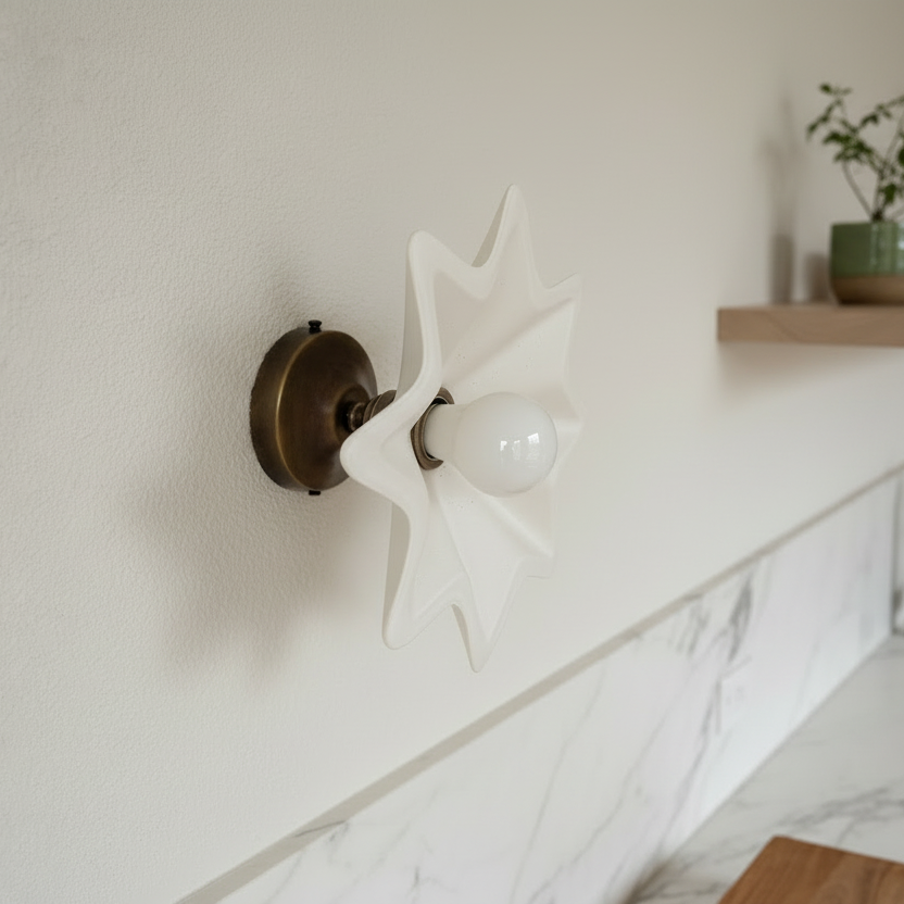 Decorative wall light fixture in a kitchen with marble countertop and wooden shelf.